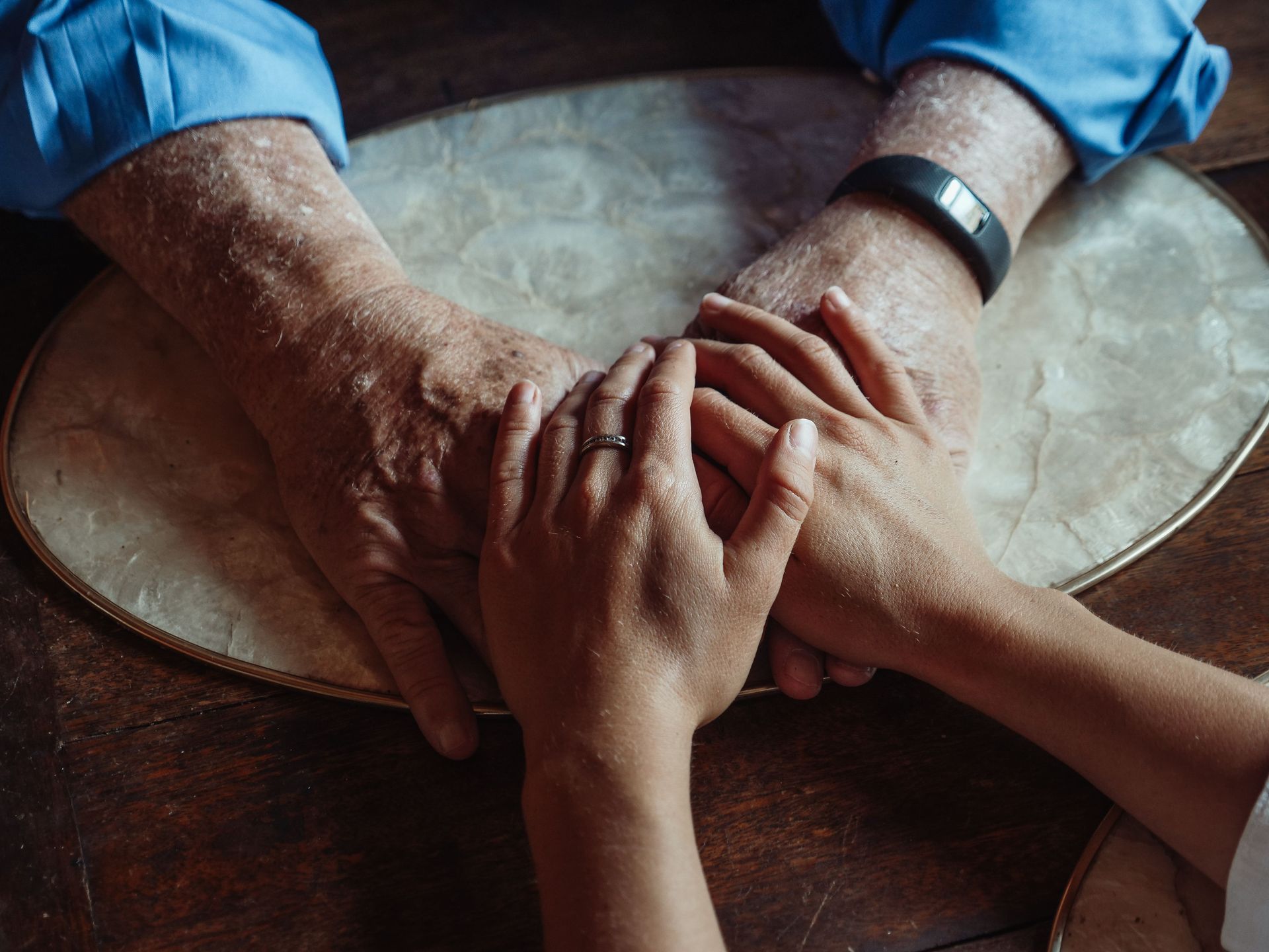 Close-up of elderly and young hands joined, symbolizing compassion and support.